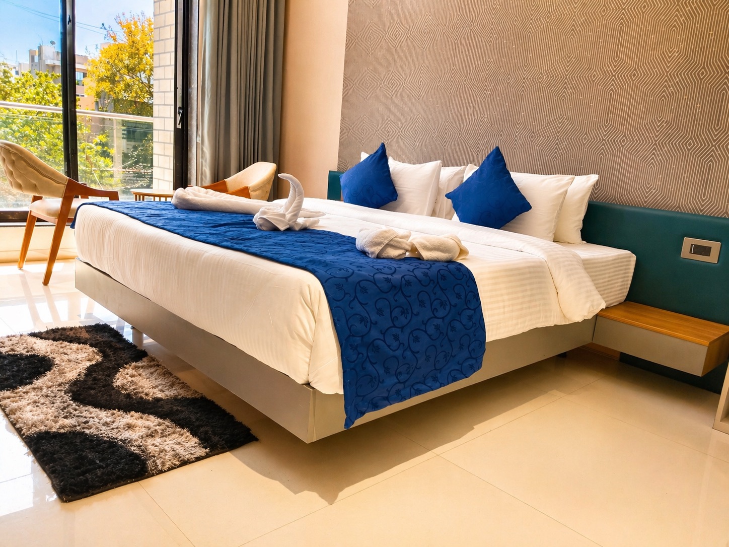 Deluxe Premium Room with a teal headboard and sunlit window